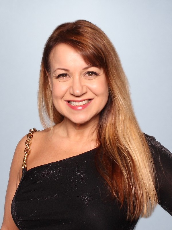 Cathryn Marshall smiling in a black one-shoulder dress