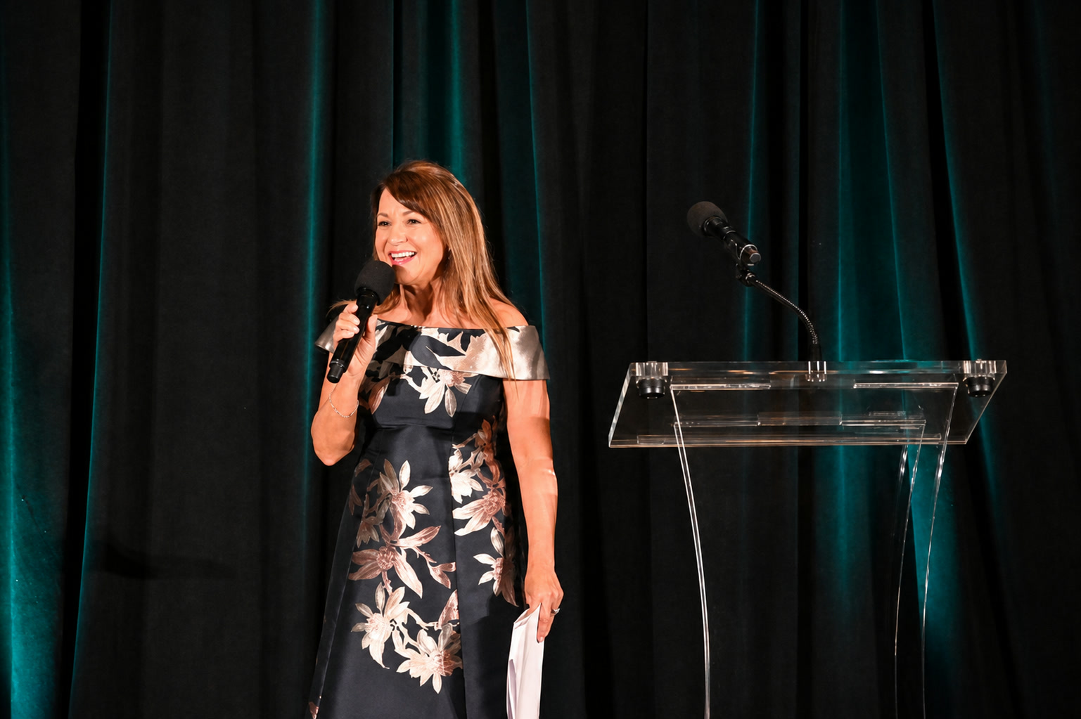 Cathryn Marshall smiling on stage in a floral dress